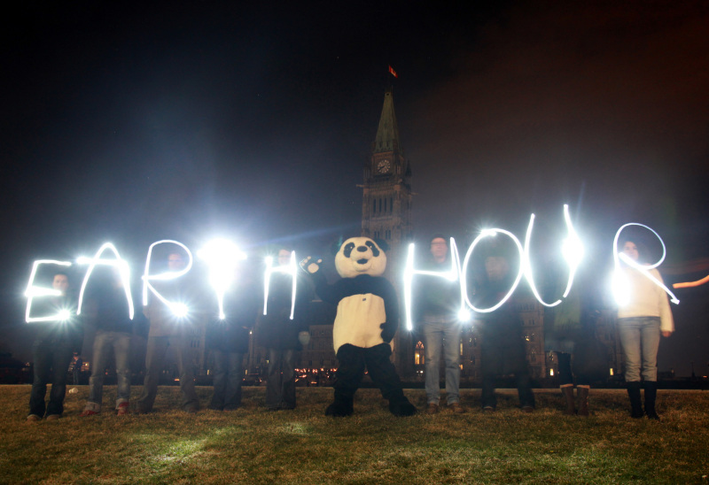 WWF supporters and the Panda mascot celebrate Earth Hour 2010 by the darkened Parliament buildings in Ottawa, Ontario, Canada. © Patrick Doyle / WWF-Canada