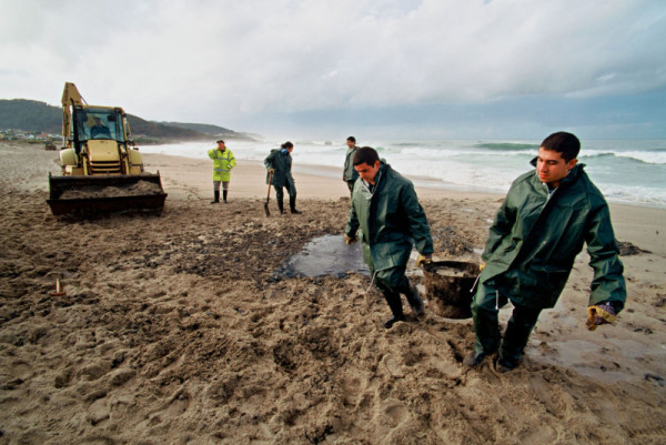 Spanish marines removing fuel oil from beach, Galicia, Spain