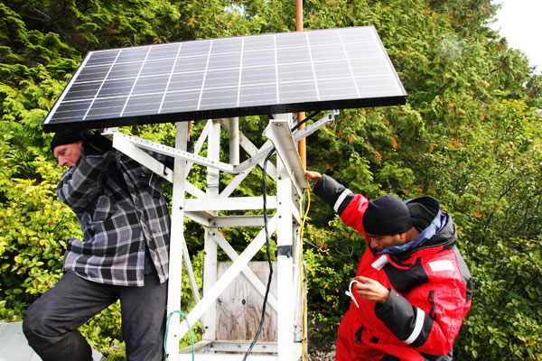 WWF’s Hussein Alidina helps Cetacea Lab’s Hermann Meuter set up a solar powered battery station to power a hydrophone.  © Jo Anne Walton / WWF-Canada