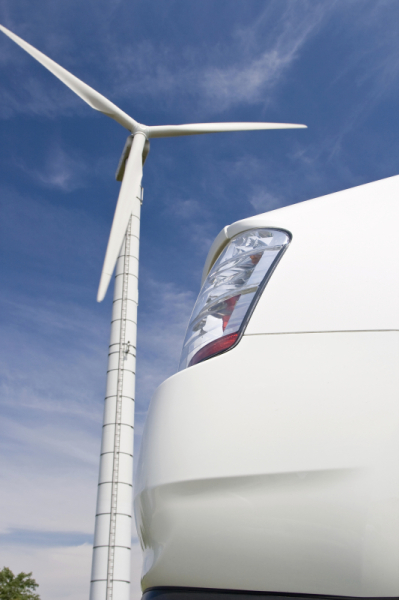 Hybrid car with wind turbine in the background against a blue sky. ©  Istockphoto.com / WWF-Canada