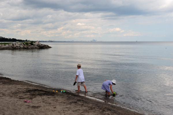 With the skyline of Toronto on the horizon, children play in the water on the shores of Lake Ontario, Ontario, Canada. © Frank PARHIZGAR / WWF-Canada