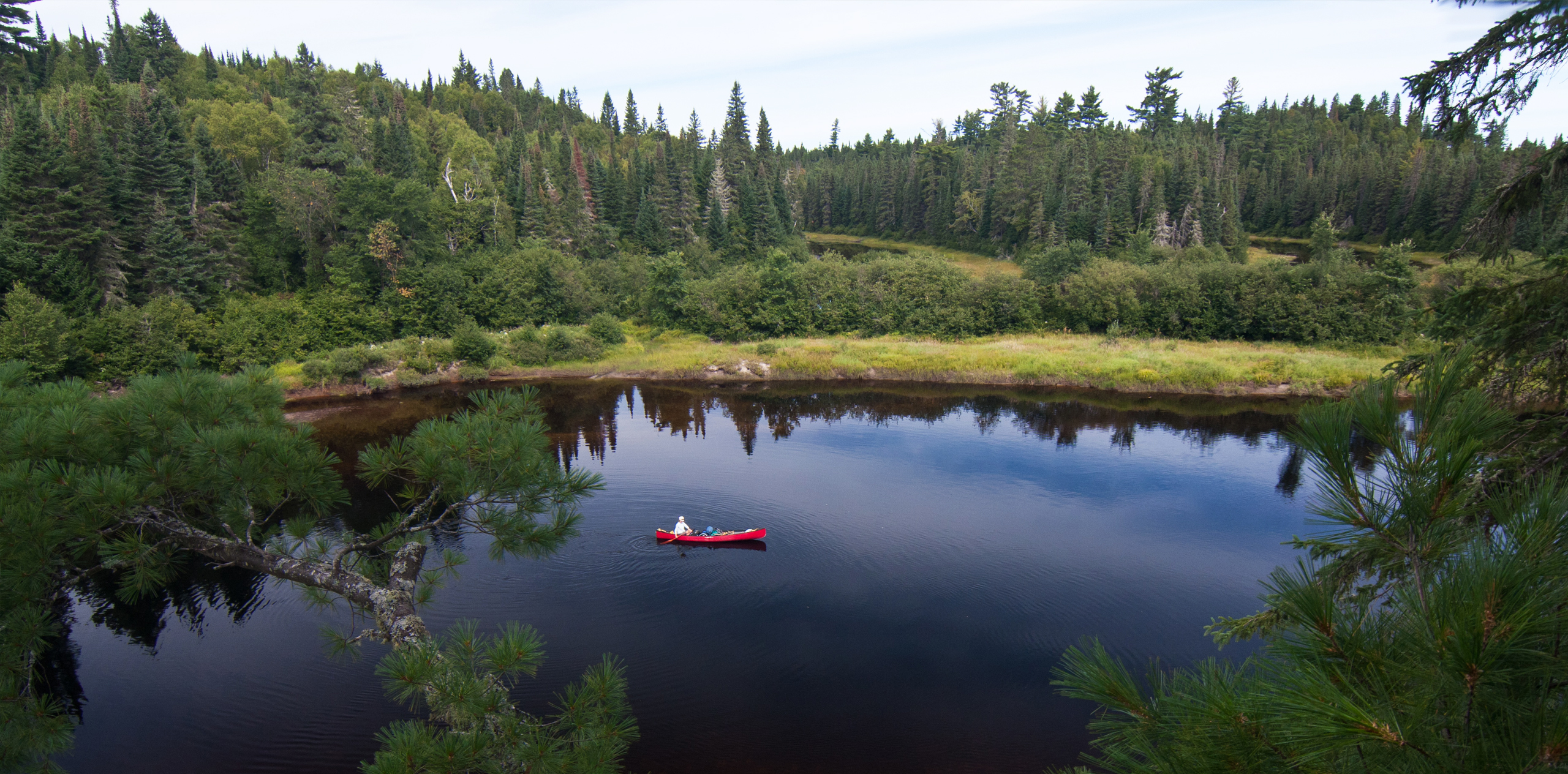 A canoeist paddling the Coulonge River in the boreal forest in Quebec, Canada