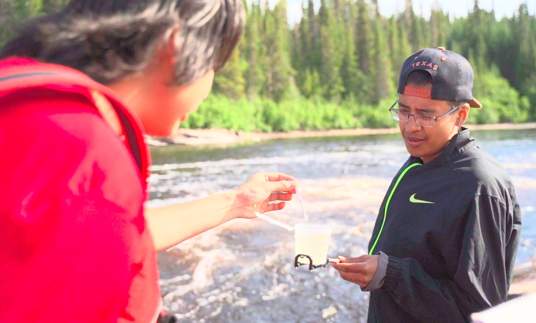 Water testing. Cree youth using the Water Rangers kit to test water from a river near