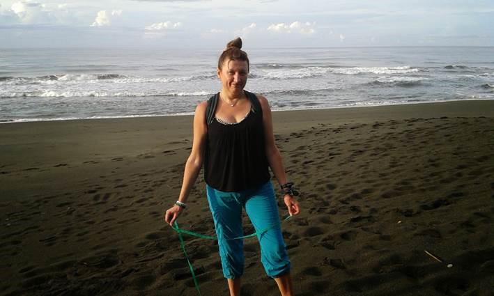 Lyudmyla on the beach in Costa Rica, holding discarded fishing rope