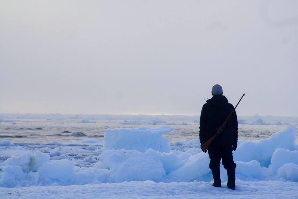 Inuk man, Max Kalluk, looking at the dea ice of Arctic Bay, Nunavut