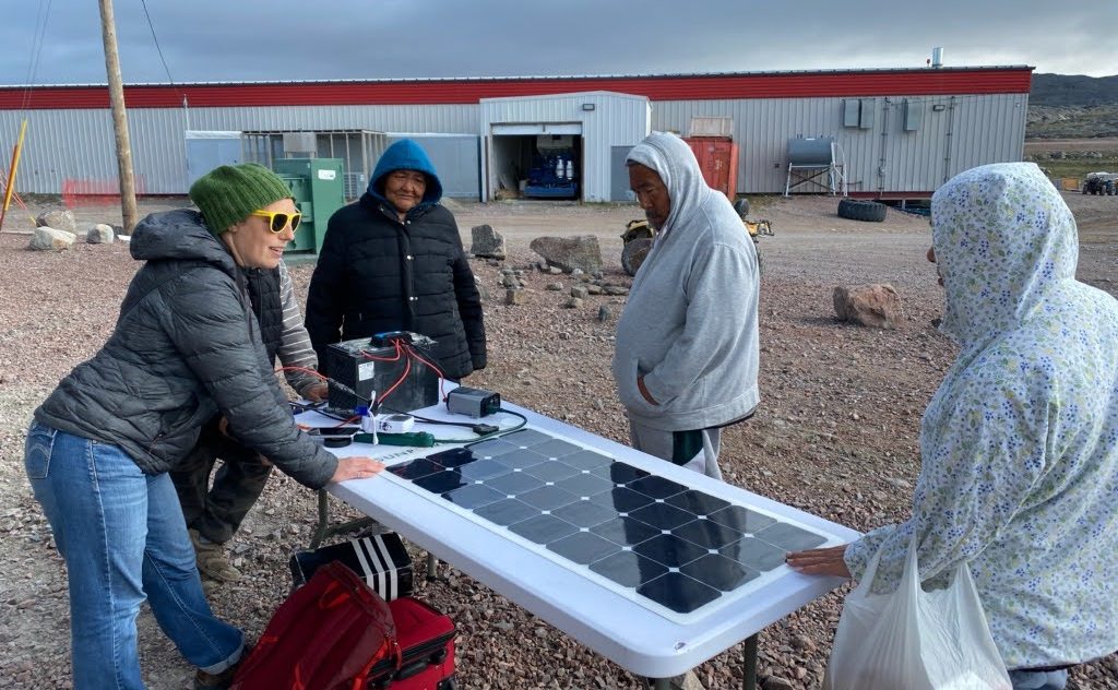 Group standing around solar panels in Nunavut