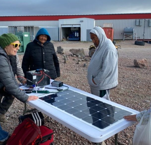Un groupe se tient autour d'un panneau solaire, au Nunavut