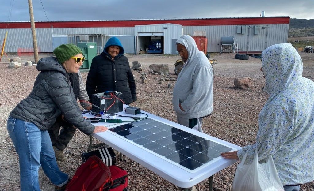 Un groupe se tient autour d'un panneau solaire, au Nunavut