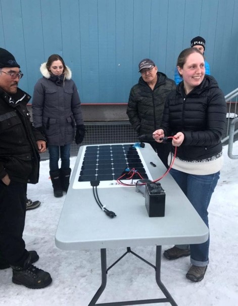 Matha Lenio présente un panneau solaire à des membres de la communauté de Gjoa Haven
