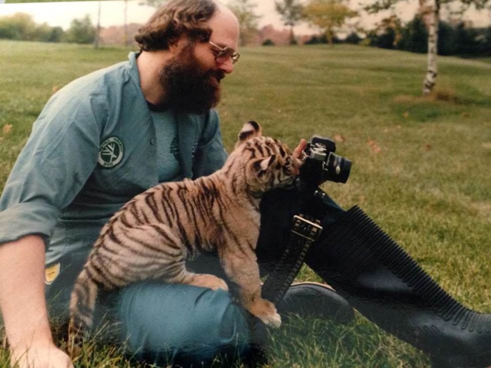 Doug Knuff sitting with tiger cub