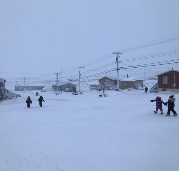 Children walk along the road in Whale Cove.