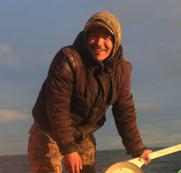 Two Inuit fisherman smiling in the sunshine while conducting research samplessamples for