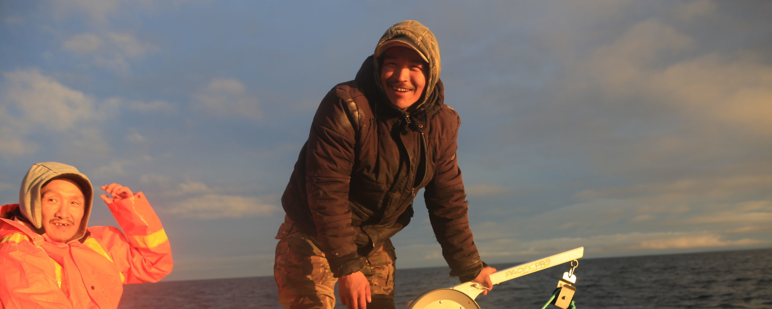 Two Inuit fisherman smiling in the sunshine while conducting research samplessamples for