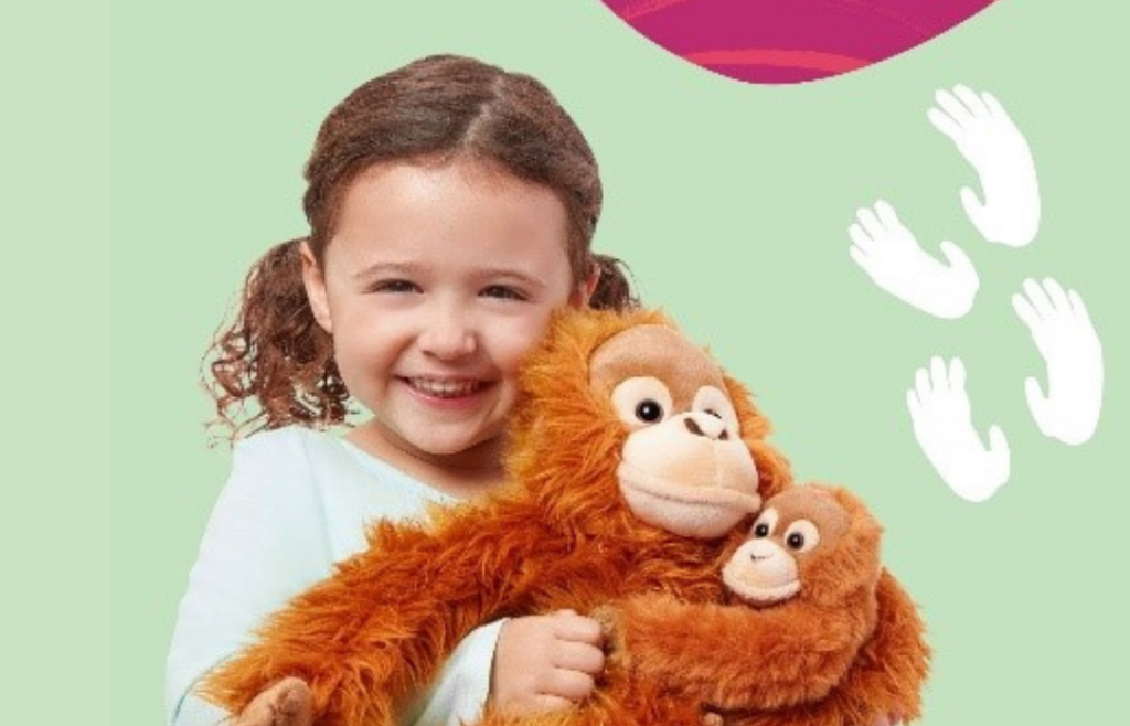 young girl cuddling an orangutan family stuffed animal