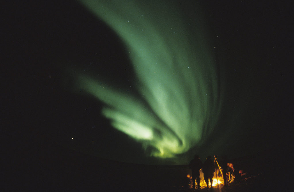 Campfire under aurora borealis