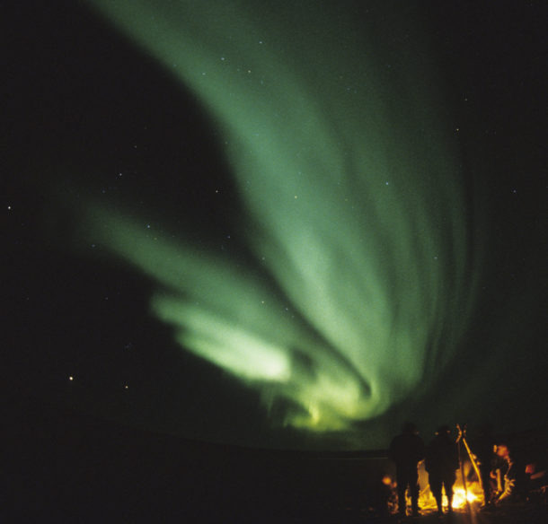 Campfire under aurora borealis
