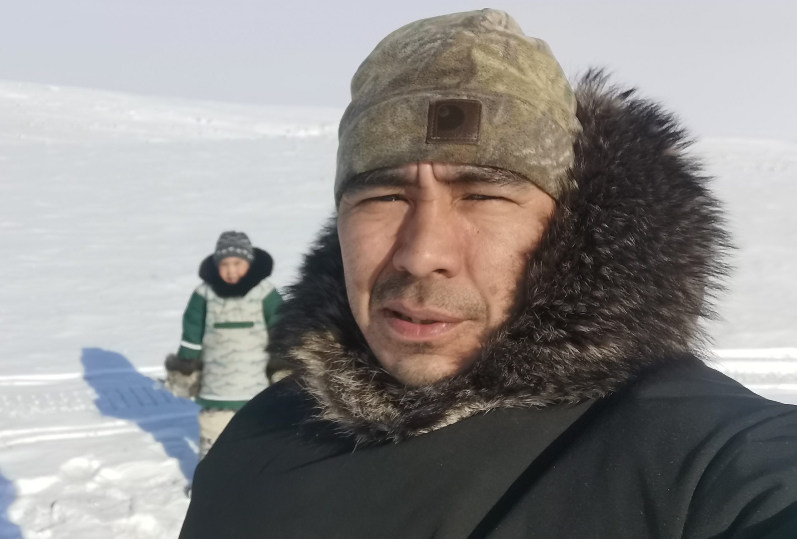 Inuit man and son out on the land in winter