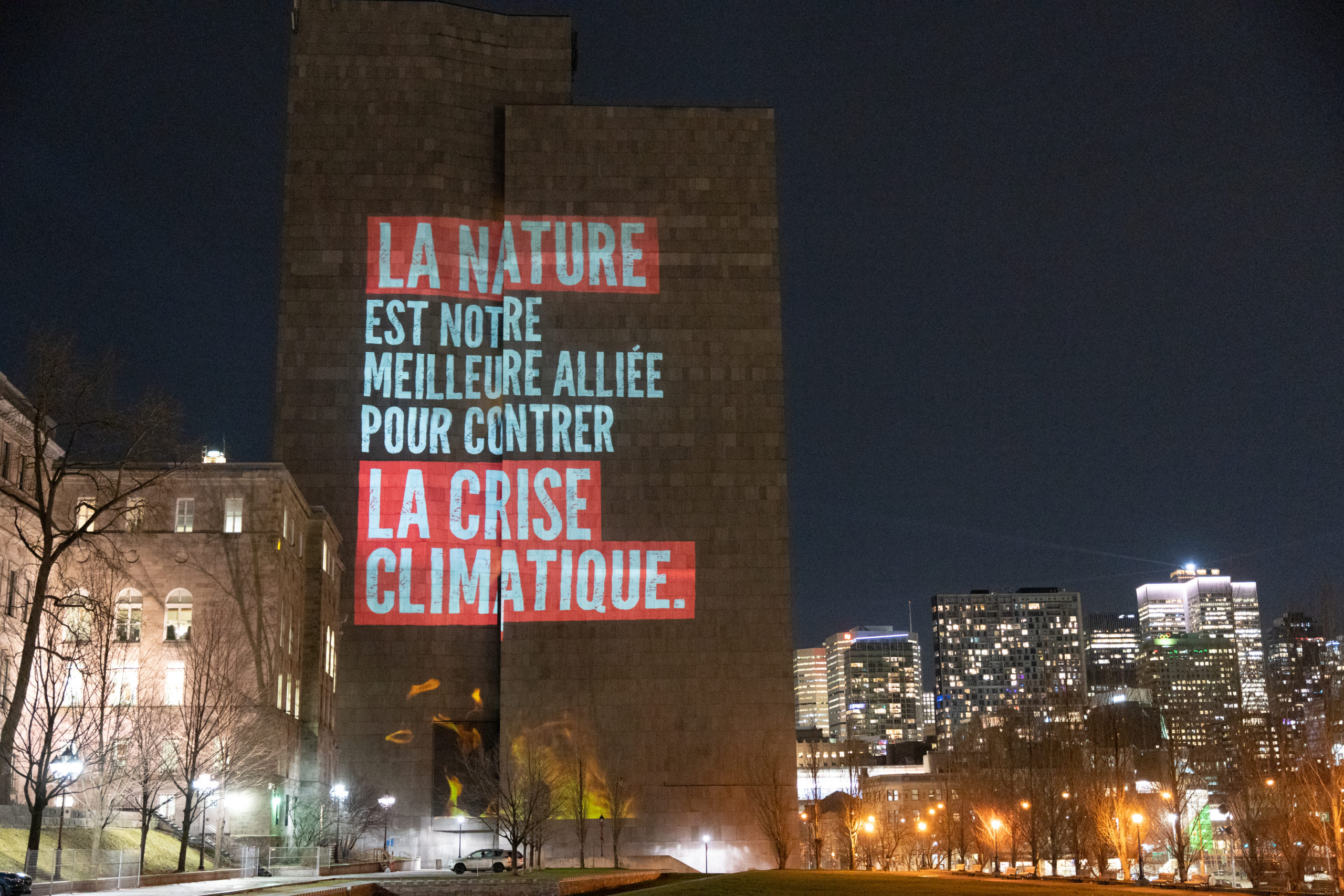 Une projection sur le mur est du Palais de justice se lit : « La nature est notre meilleure alliée pour contrer la crise climatique » 
