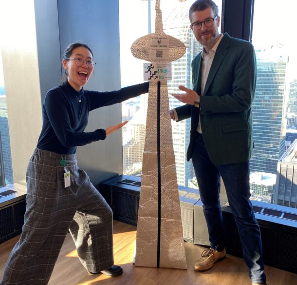 Monica and Scott from TD pose by a replica of the CN Tower.