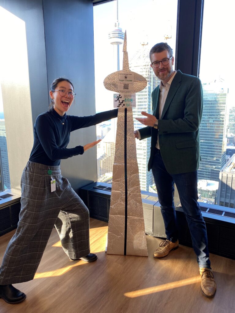 Monica and Scott from TD pose by a replica of the CN Tower.