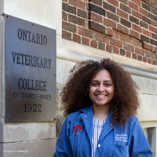 Living Planet Leader Youstina Makhlouf smiles while standing in front of a brick Ontario Veterinary College building