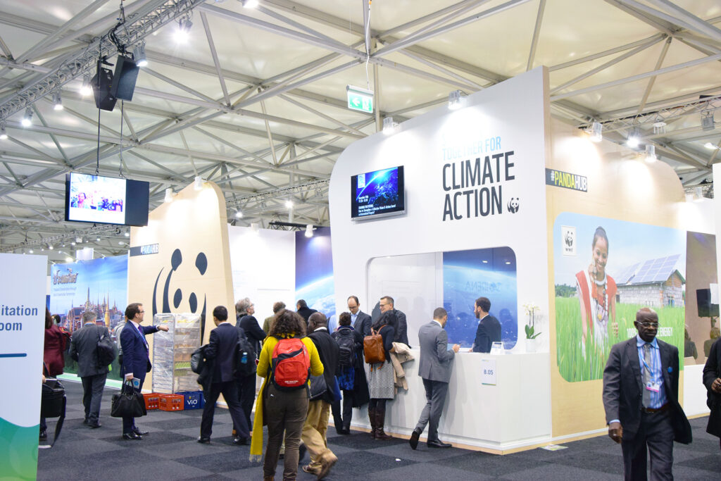 Climate COP attendees at WWF’s PandaHub pavilion, the walls feature the WWF panda logo and the words Climate Action 