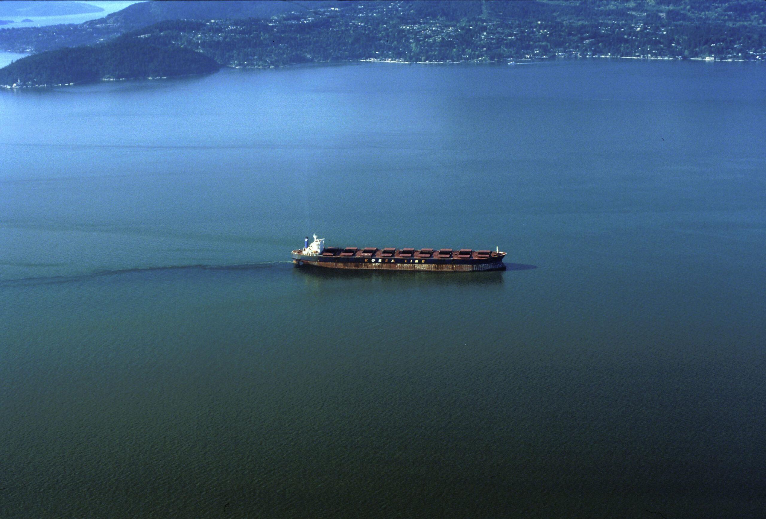 Freight ship dumping its bilge near Vancouver harbour, oil slick showing in the ship's wake