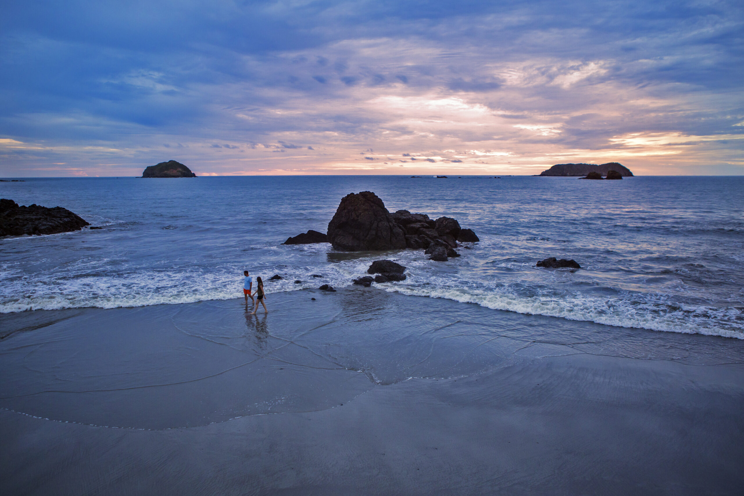 Couple walking on a Costa Rican beach at sunset