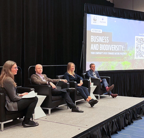 Two women and two men sitting on a stage, next to a projection that says Action Plan Business and Biodiversity: Your company’s path toward nature positivity. Presented in partnership with Aviva Canada.