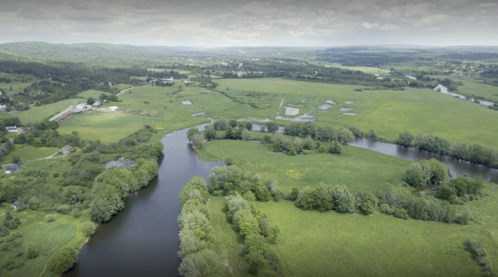 Aerial view of a winding river in a mostly agricultural land. 