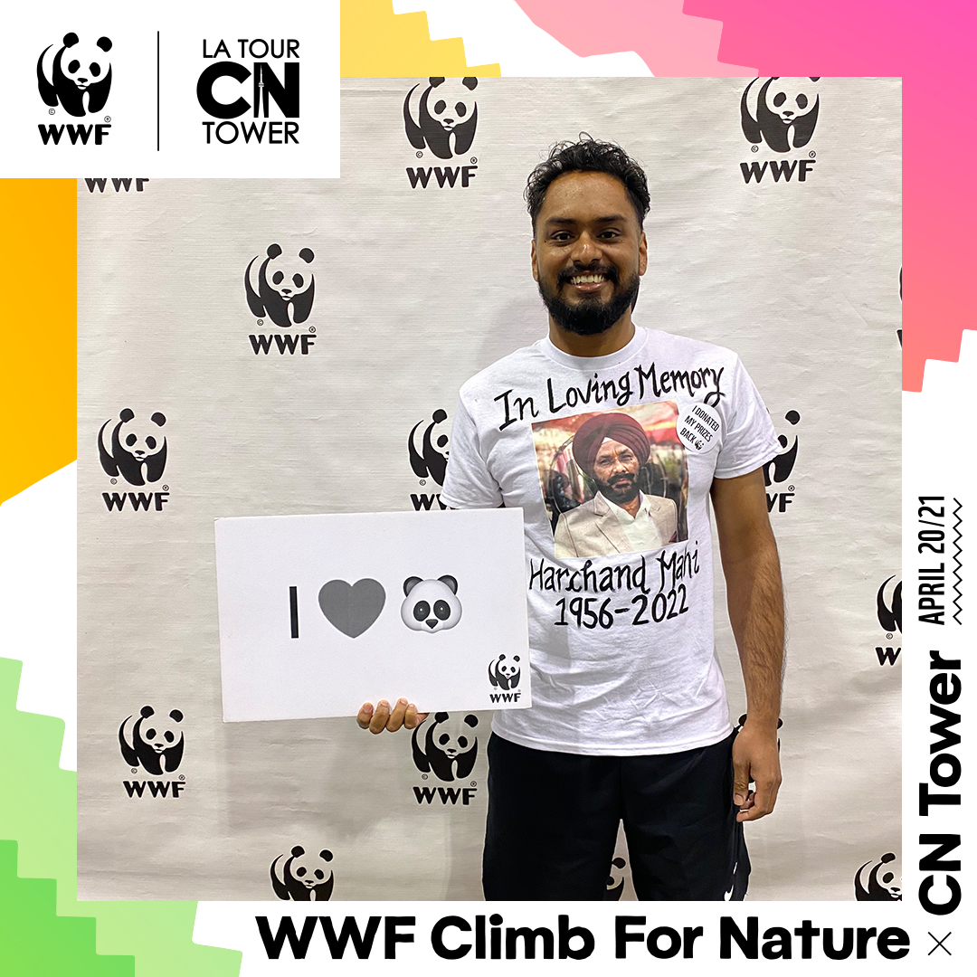 Harman Mahi poses with an "I love Panda" sign at the 2023 CN Tower Climb for Nature.