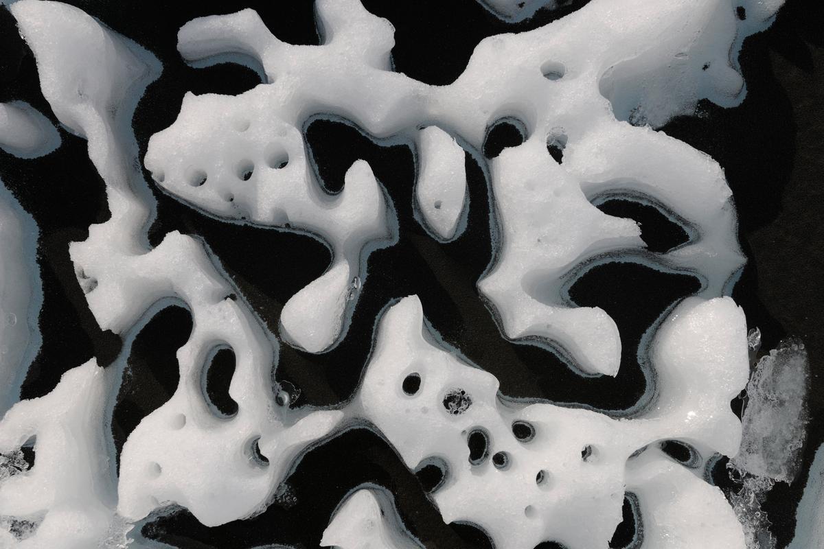 Close-up image of ice melting around black particulate matter