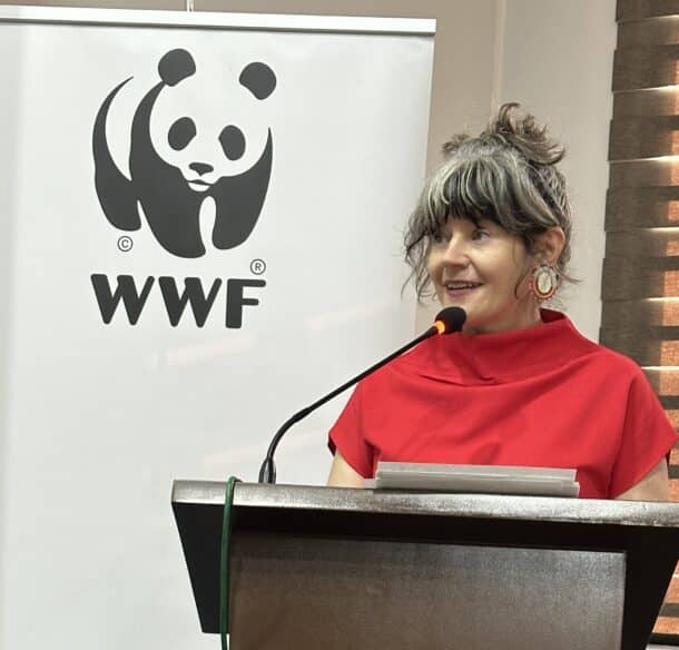 Woman at a podium with a WWF panda logo behind her