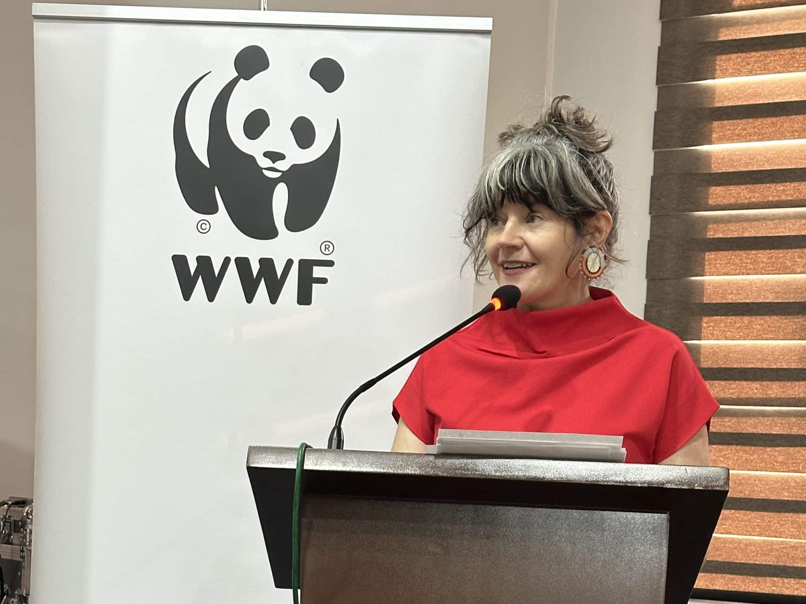 Woman at a podium with a WWF panda logo behind her