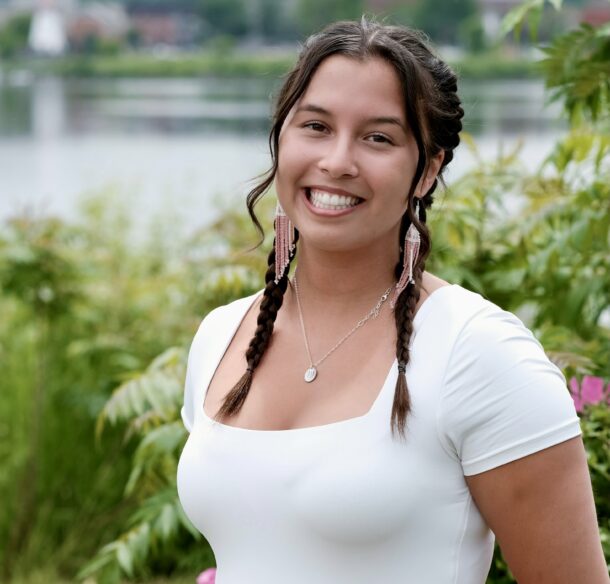 Kianna Bear-Hetherington, a Water Guardian from Wolastoqey Nation smiling in front of the water.