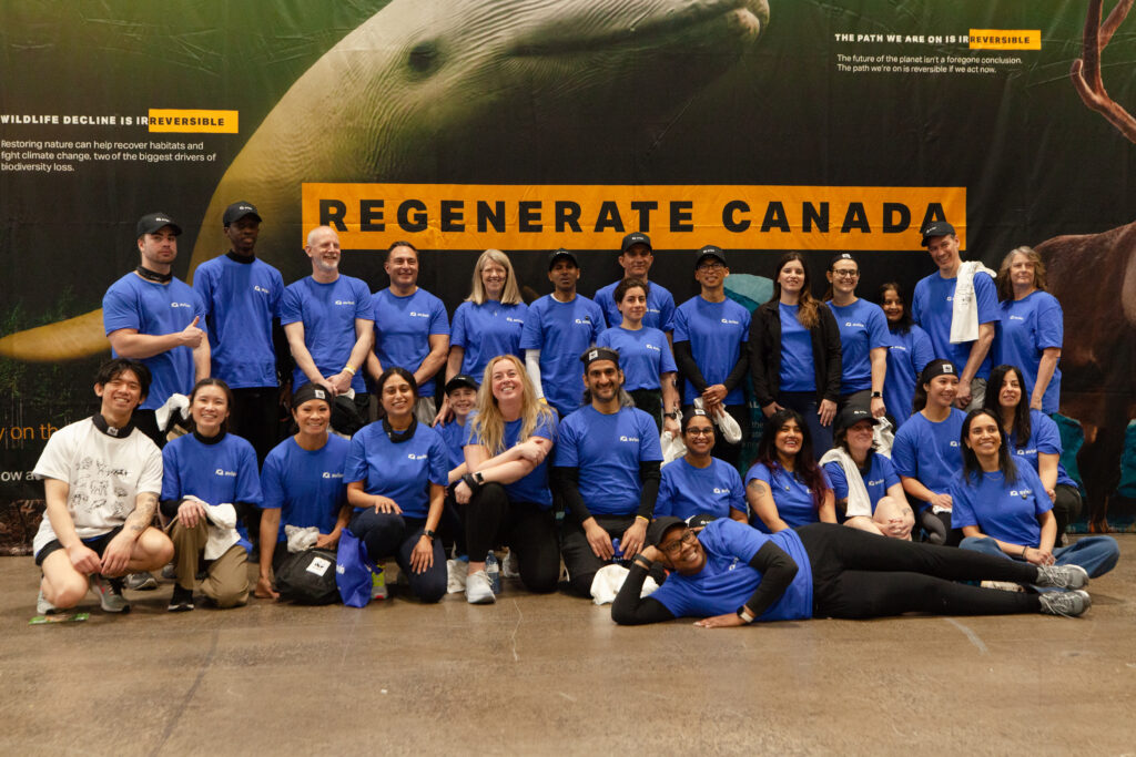 a group of people standing in front of a sign that says regenerate canada