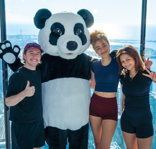 Harrison Browne, Ksenia Kharlamova and Anastasia Kharlamova celebrate at the top of the CN Tower with WWF's panda mascot on May 2.
