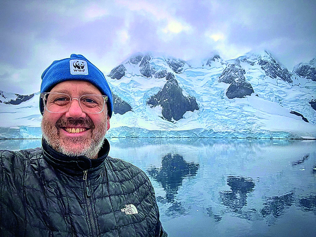 man taking a selfie with glaciers behind him