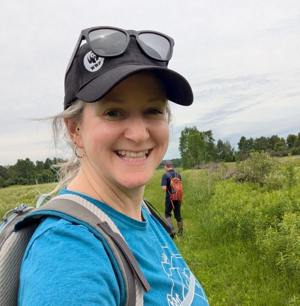 A woman wearing a hat and sunglasses taking a selfie