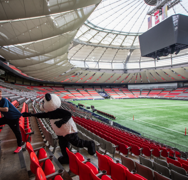 WWF's panda mascot chasing Shaun Stephens-Whale, the fastest climber, up the stairs of BC Place's lower bowl.