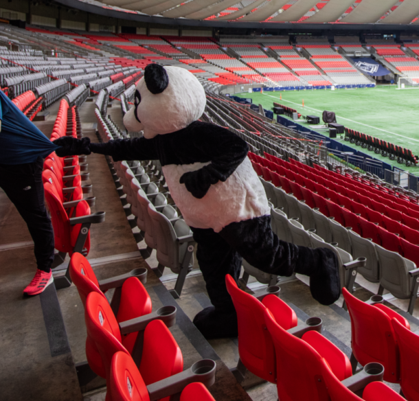 WWF's panda mascot chasing Shaun Stephens-Whale, the fastest climber, up the stairs of BC Place's lower bowl.