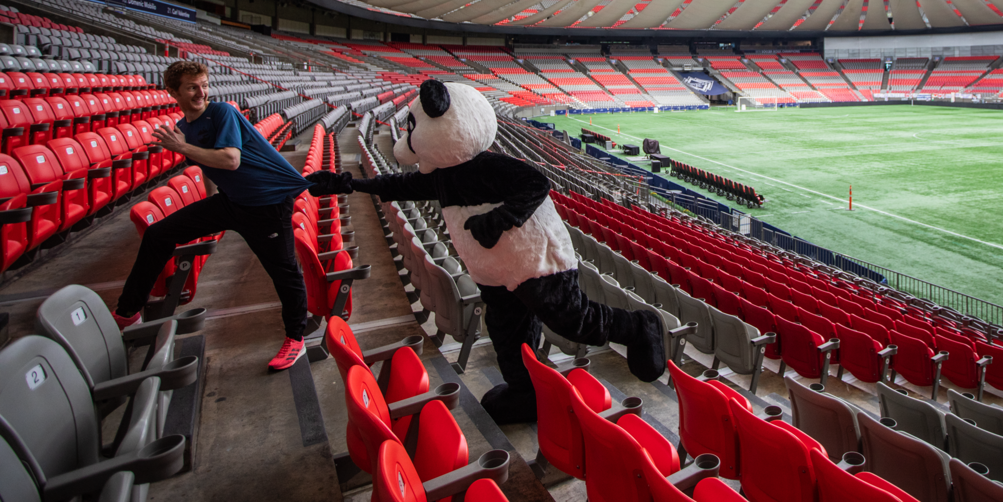 WWF's panda mascot chasing Shaun Stephens-Whale, the fastest climber, up the stairs of BC Place's lower bowl.