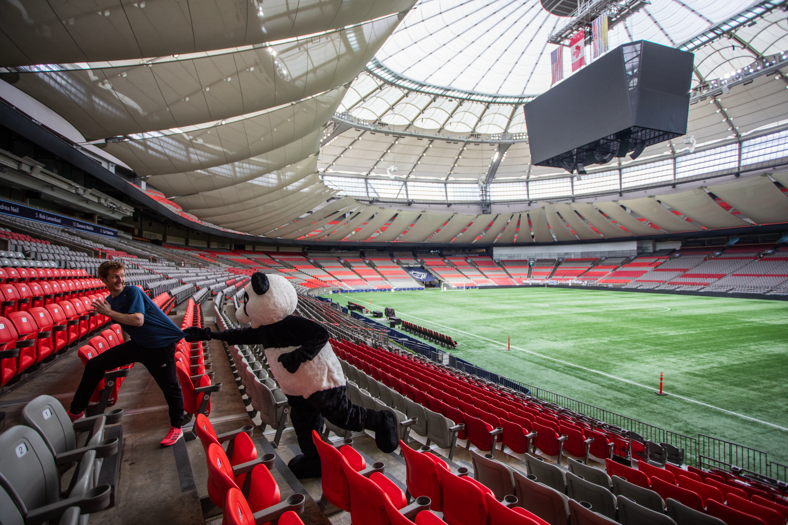 WWF's panda mascot chasing Shaun Stephens-Whale, the fastest climber, up the stairs of BC Place's lower bowl.